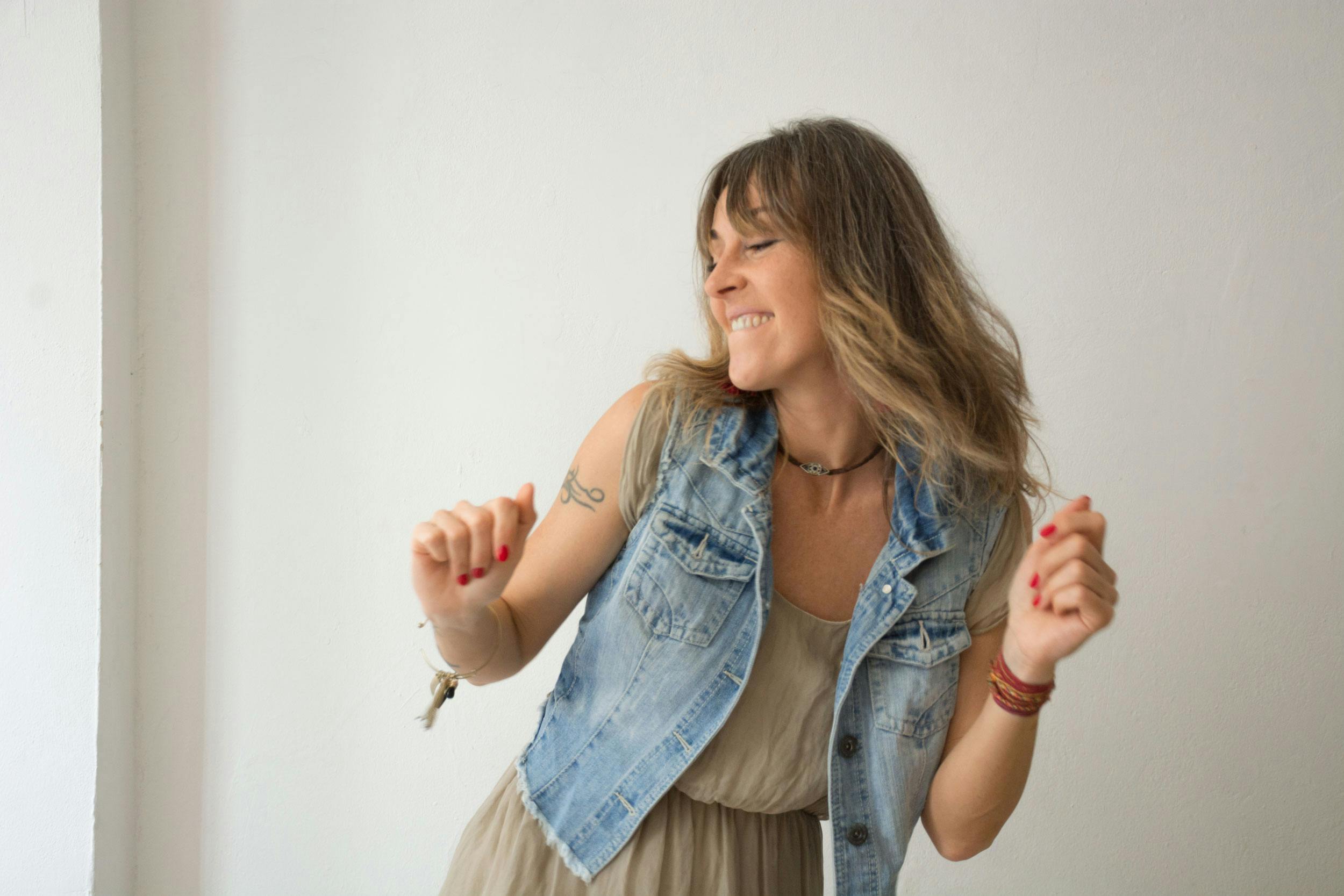 Smiling woman enjoying a dance, expressing joy and freedom inside.